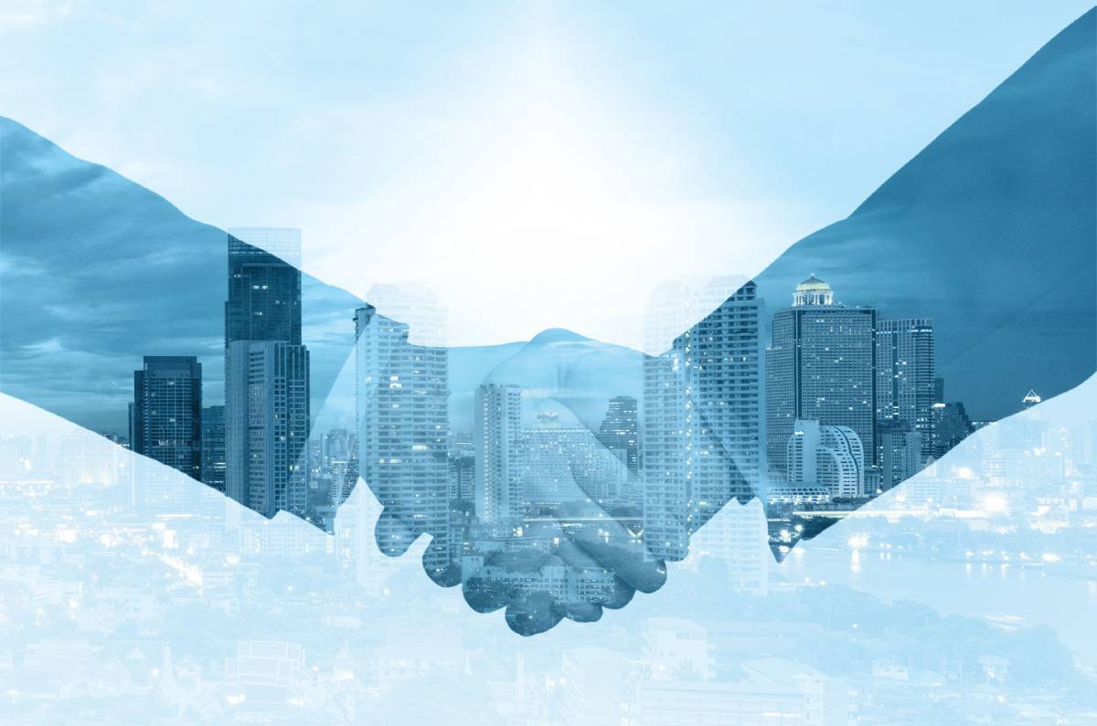 Double exposure of business people shaking hands with city skyline background.