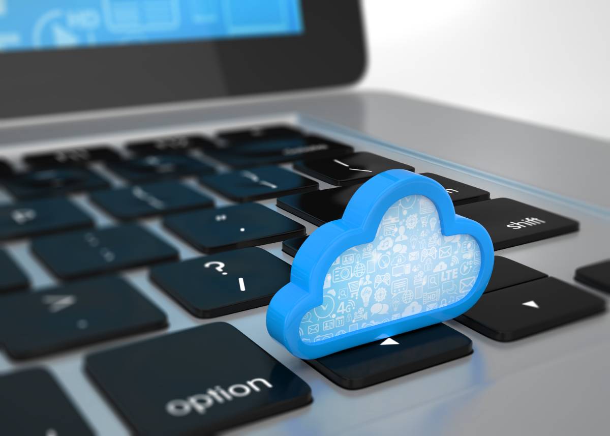 A blue cloud sitting on the directional keys of a laptop